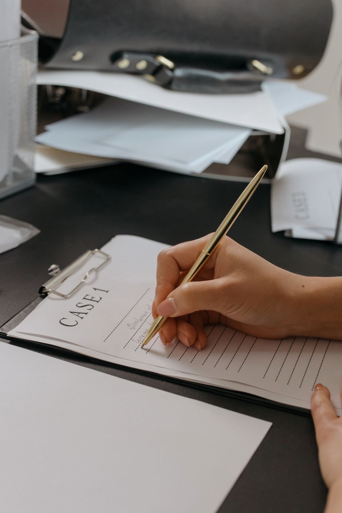 Hand filling out a business form pad at a desk
