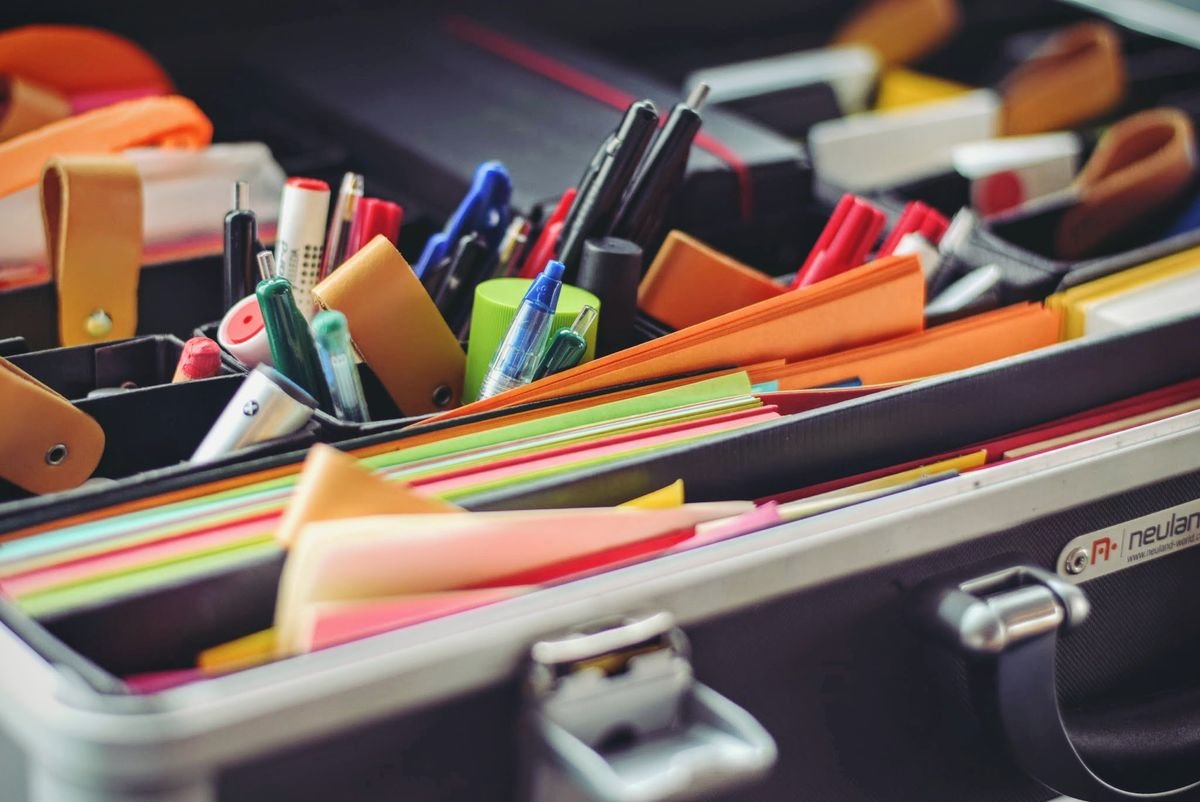 Assorted writing tools and markers arranged in a stationery case