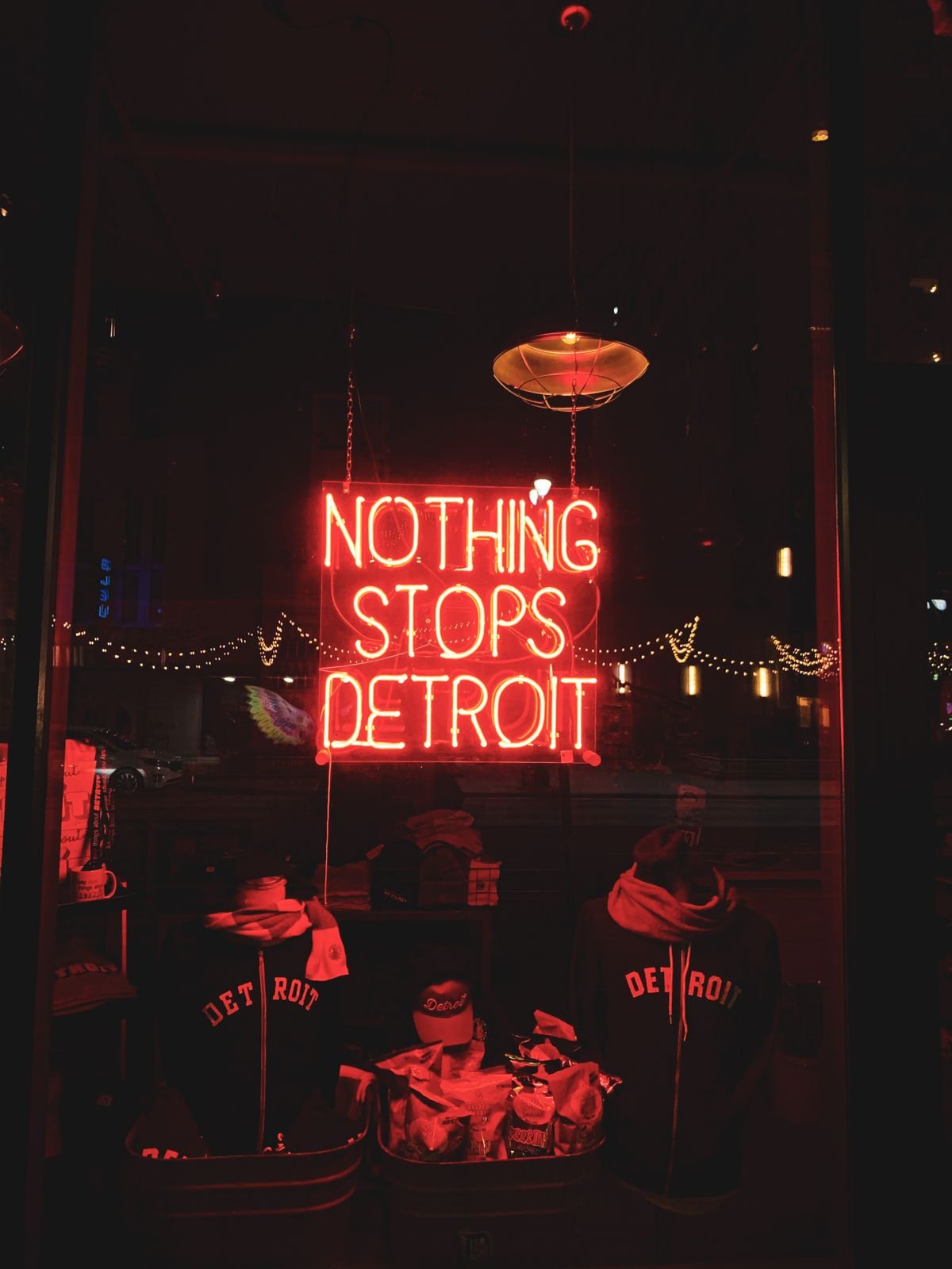 Representative neon-style illuminated sign viewed at night through a storefront window