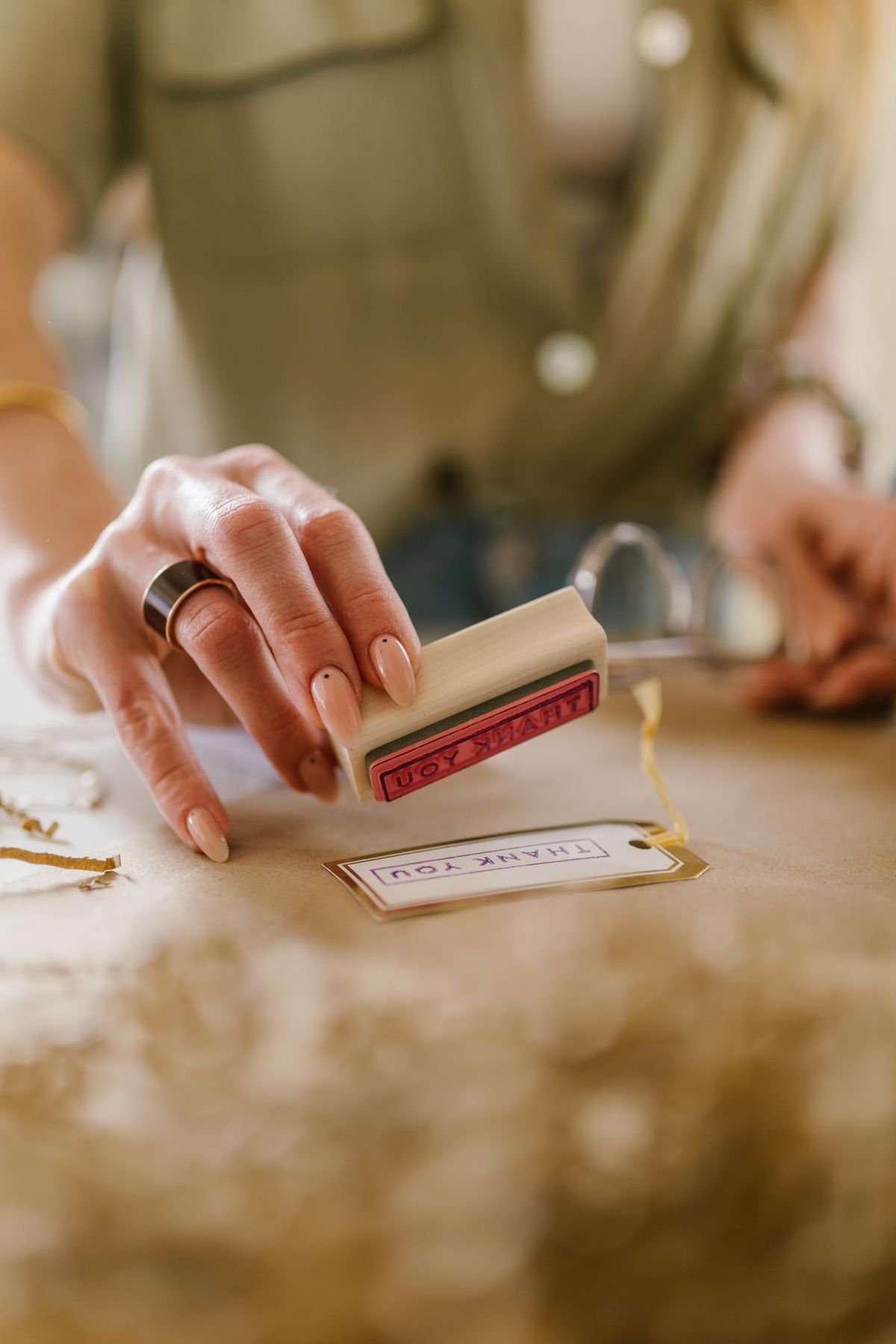 Hand pressing a wooden rubber stamp onto a card